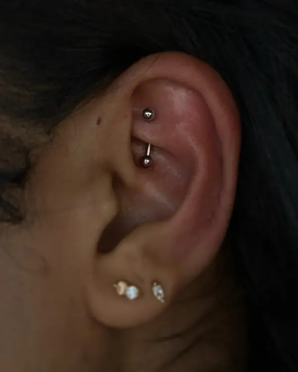Rook piercing with a curved barbell and gemstone lobe studs by T (Piercing Piranha) at Modified Tattoo Gallery in Winter Park, FL