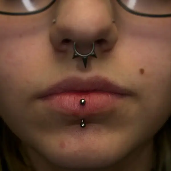 Septum piercing with a spiked clicker and a vertical labret lip piercing by T (Piercing Piranha) at Modified Tattoo Gallery in Winter Park, FL