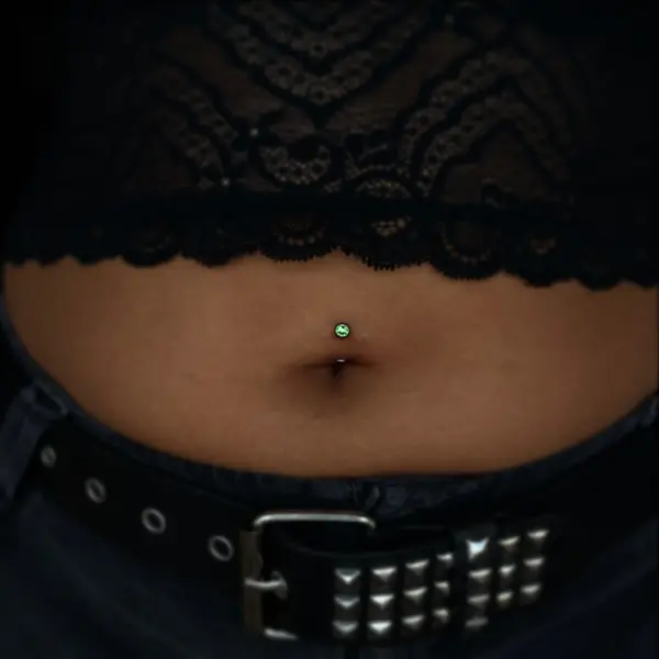 Navel (belly button) piercing with a green gem by T (Piercing Piranha) at Modified Tattoo Gallery in Winter Park, FL