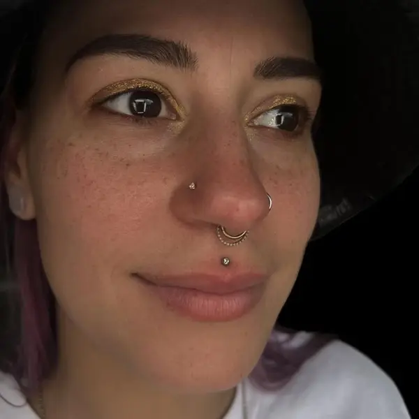 Septum, high nostril, and philtrum (medusa) piercings with gold jewelry by T (Piercing Piranha) at Modified Tattoo Gallery in Winter Park, FL