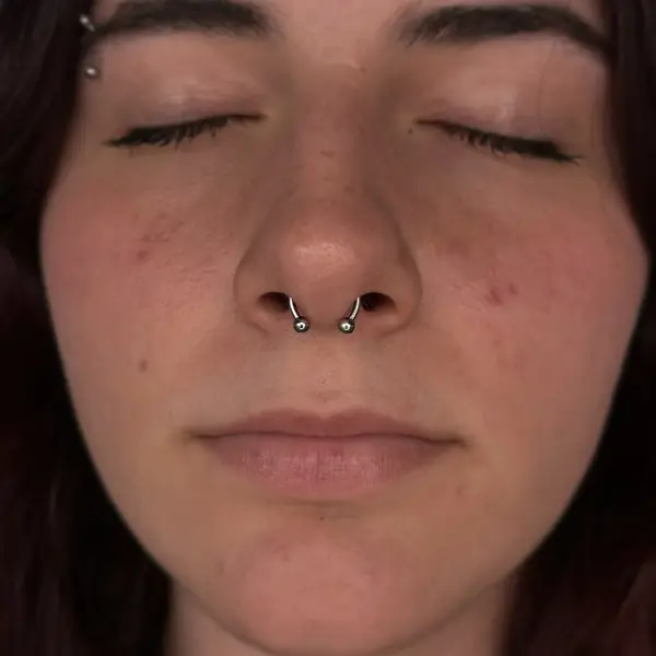 Septum piercing with a circular barbell and an eyebrow piercing by T (Piercing Piranha) at Modified Tattoo Gallery in Winter Park, FL