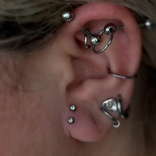 Curated ear with industrial, daith, conch, and helix piercings by T (Piercing Piranha) at Modified Tattoo Gallery in Winter Park, FL