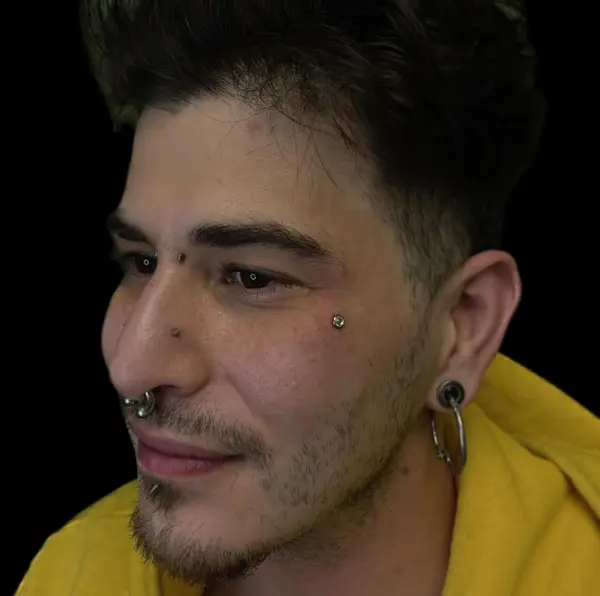 Bridge piercing, an anti-eyebrow piercing, a septum, and stretched lobes with hoops by T (Piercing Piranha) at Modified Tattoo Gallery in Winter Park, FL