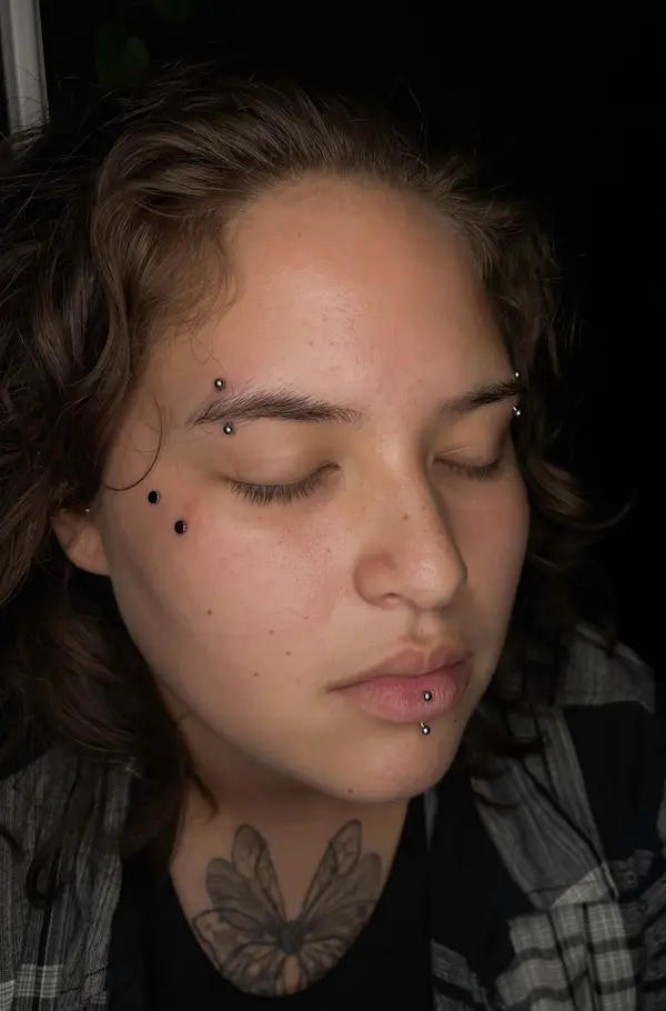 Multiple facial piercings including eyebrow, bridge, and labret by T (Piercing Piranha) at Modified Tattoo Gallery in Winter Park, FL