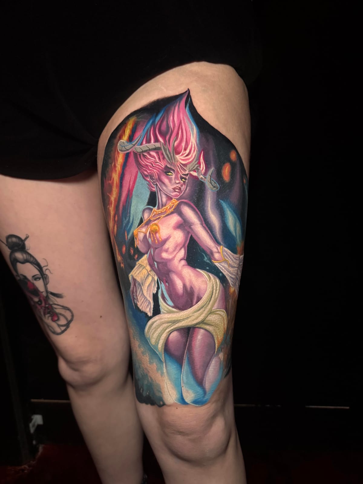Vibrant full-color realism tattoo of a horned fire demoness on the thigh by Justen Borrero at Modified Tattoo Gallery in Winter Park, FL